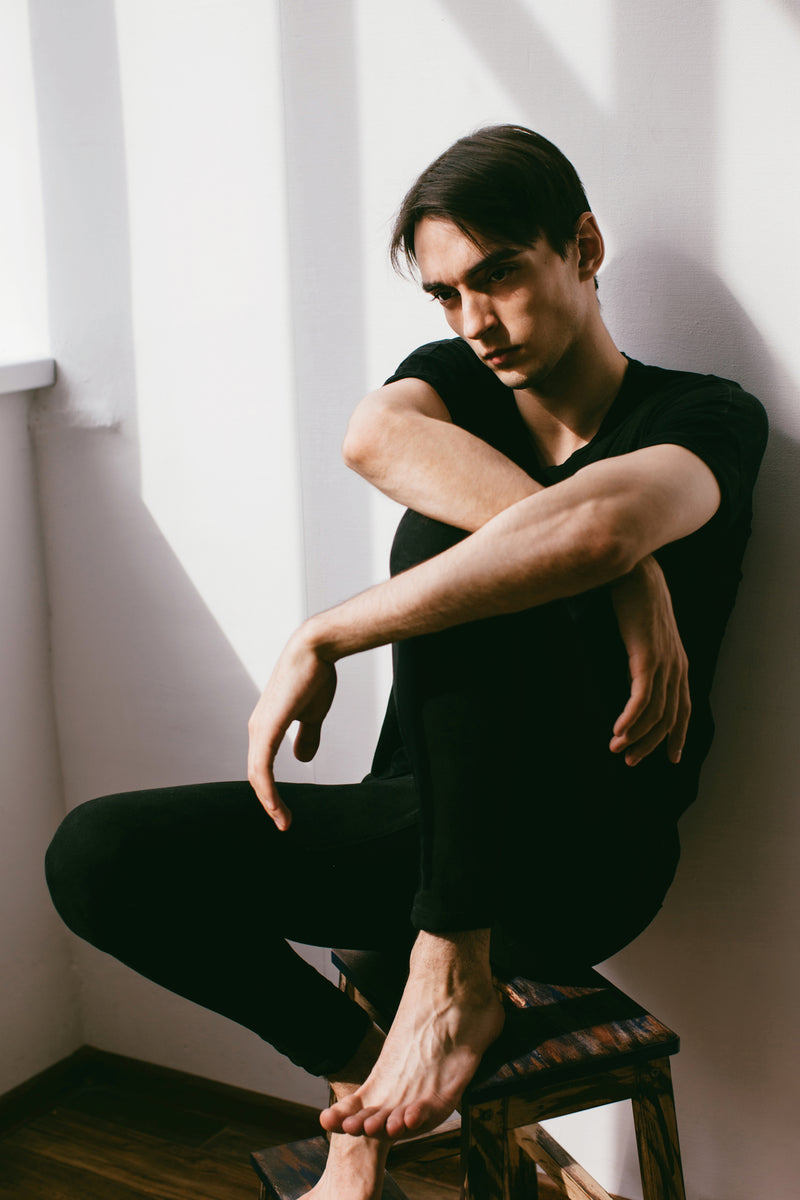 A man sitting on a stool with his arms crossed