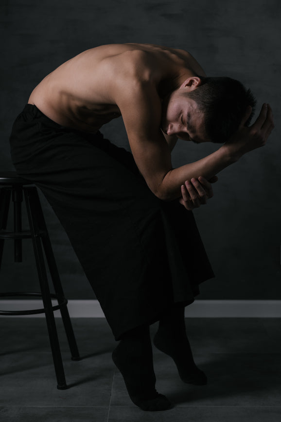 A man bending in a darkened room