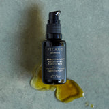 Our face oil serum bottle Cannacomplex™ Nourishing Face Serum on a splash of its oil.