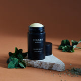 Relief Balme is a pain relief balm placed on a marble surface with mint leaves next to it.